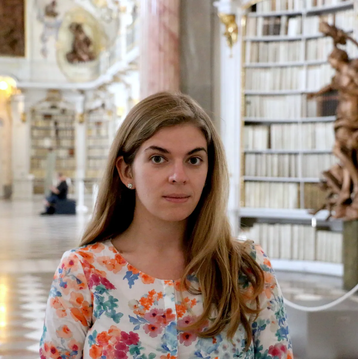 Carly in a floral blouse inside the baroque Admont Abbey library