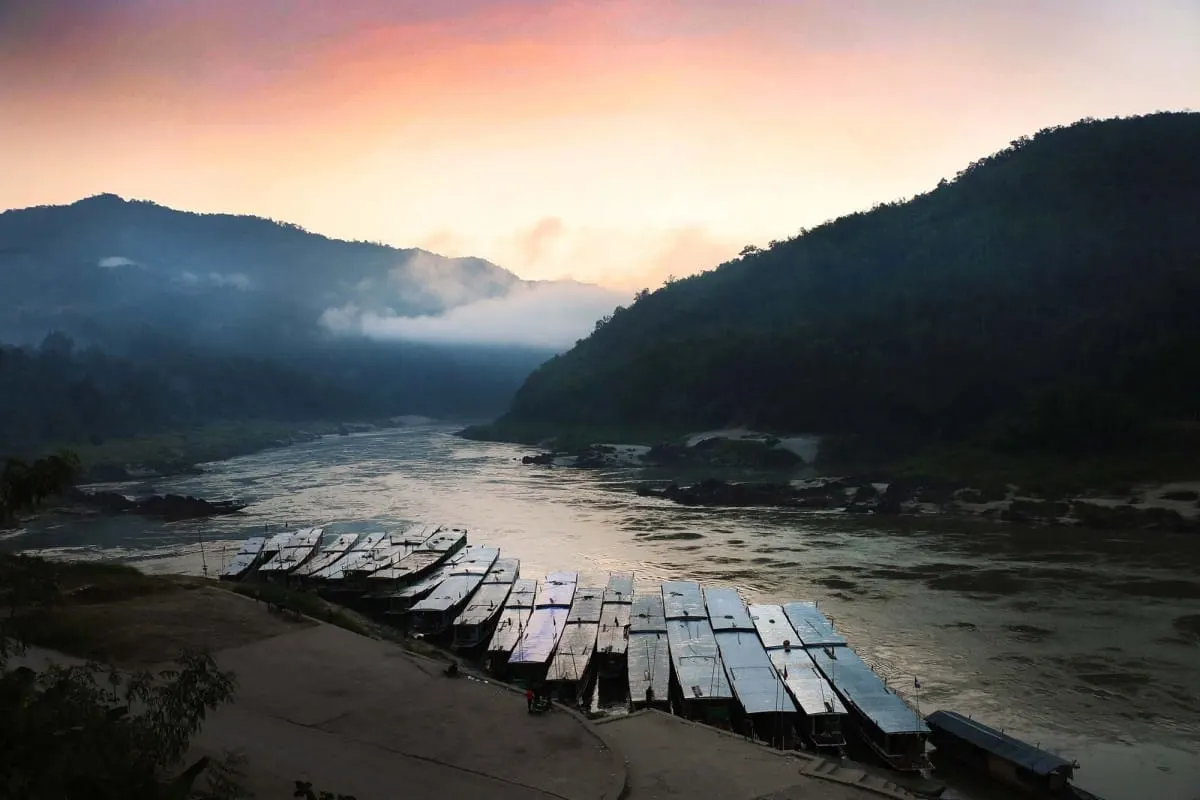 Mekong slow boats moored at a riverbank at dawn, Laos