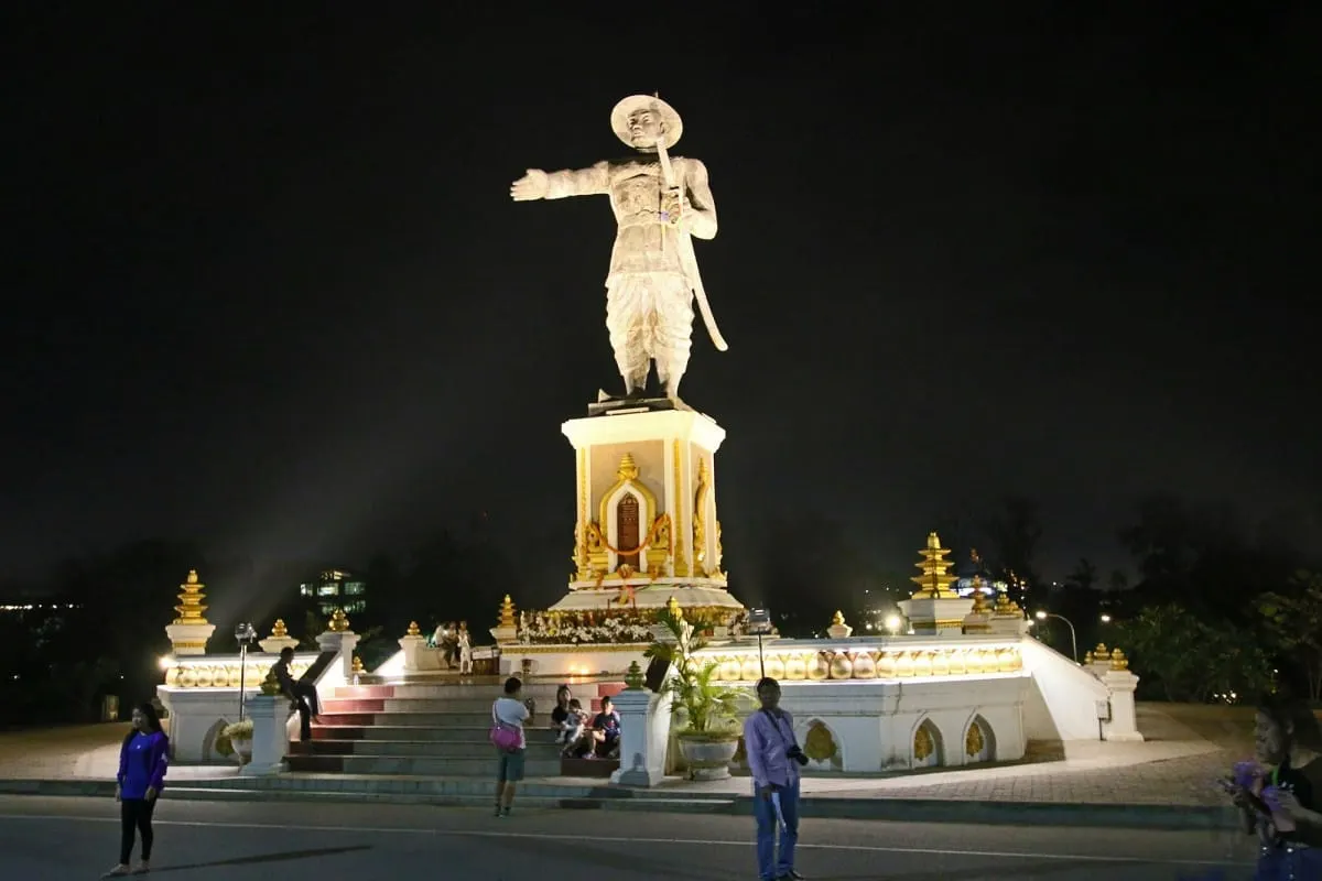 Illuminated statue of King Chao Anouvong at night on the Vientiane riverfront.