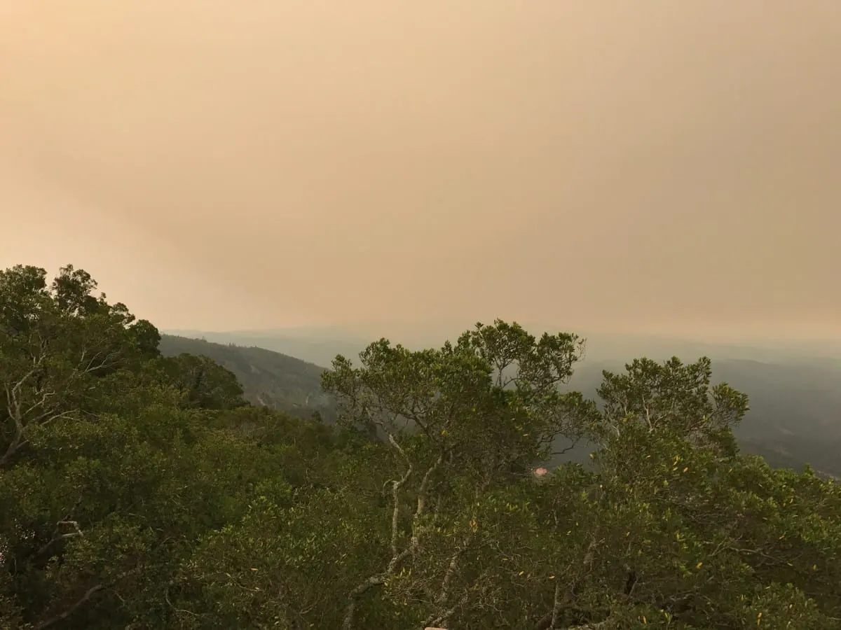 Orange smoke-filled sky over wooded hills during the 2017 wildfire