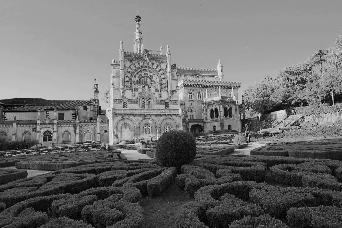 Black-and-white view of Bussaco Palace behind its patterned hedge garden