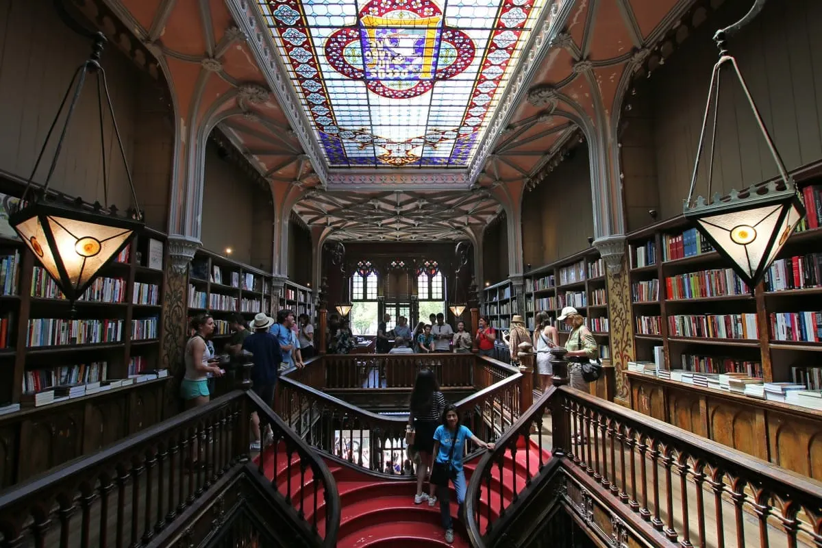 Top floor of Livraria Lello with stained-glass skylight and red staircase