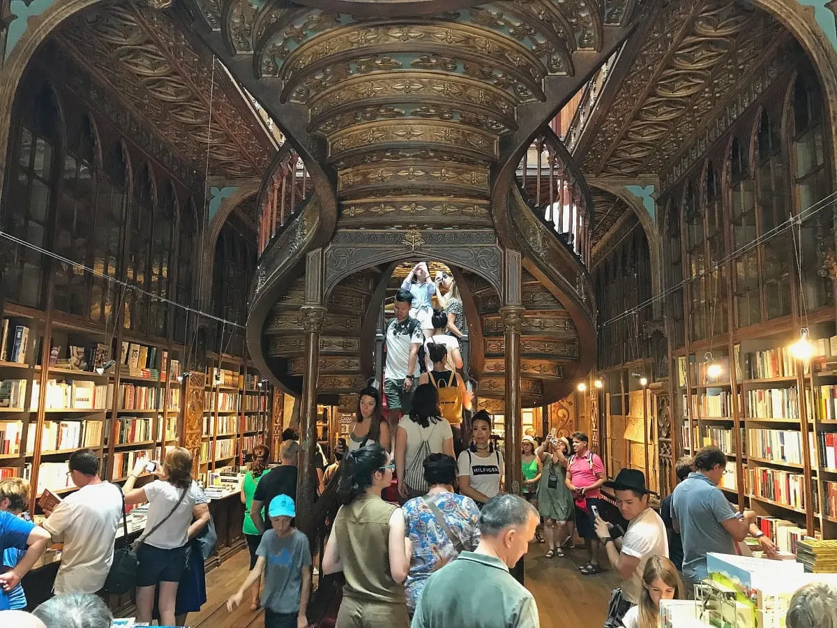 Visitors on the carved wooden staircase of Livraria Lello in Porto