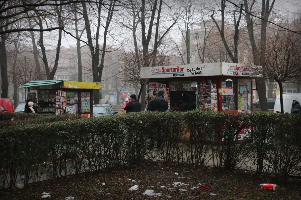 Newspaper kiosks in a foggy winter park in Arad
