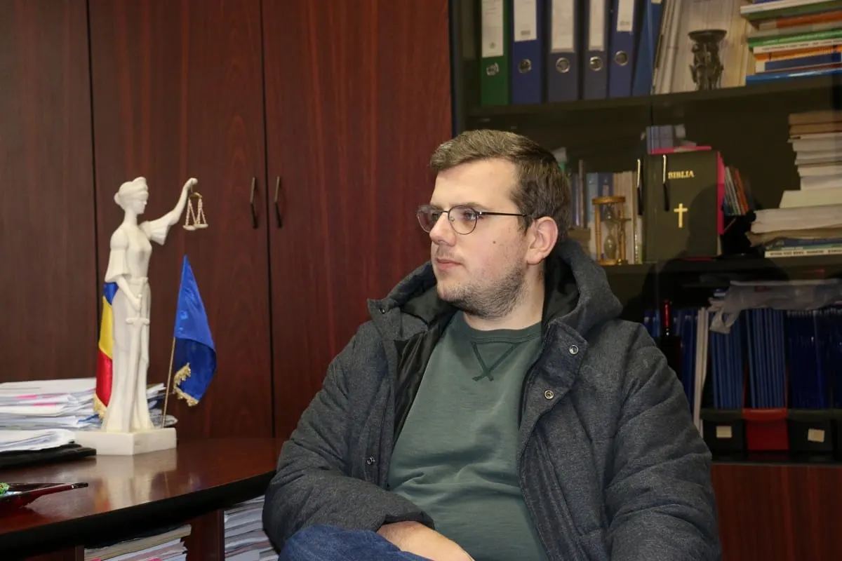 Man waiting in a notary office beside a Lady Justice statue