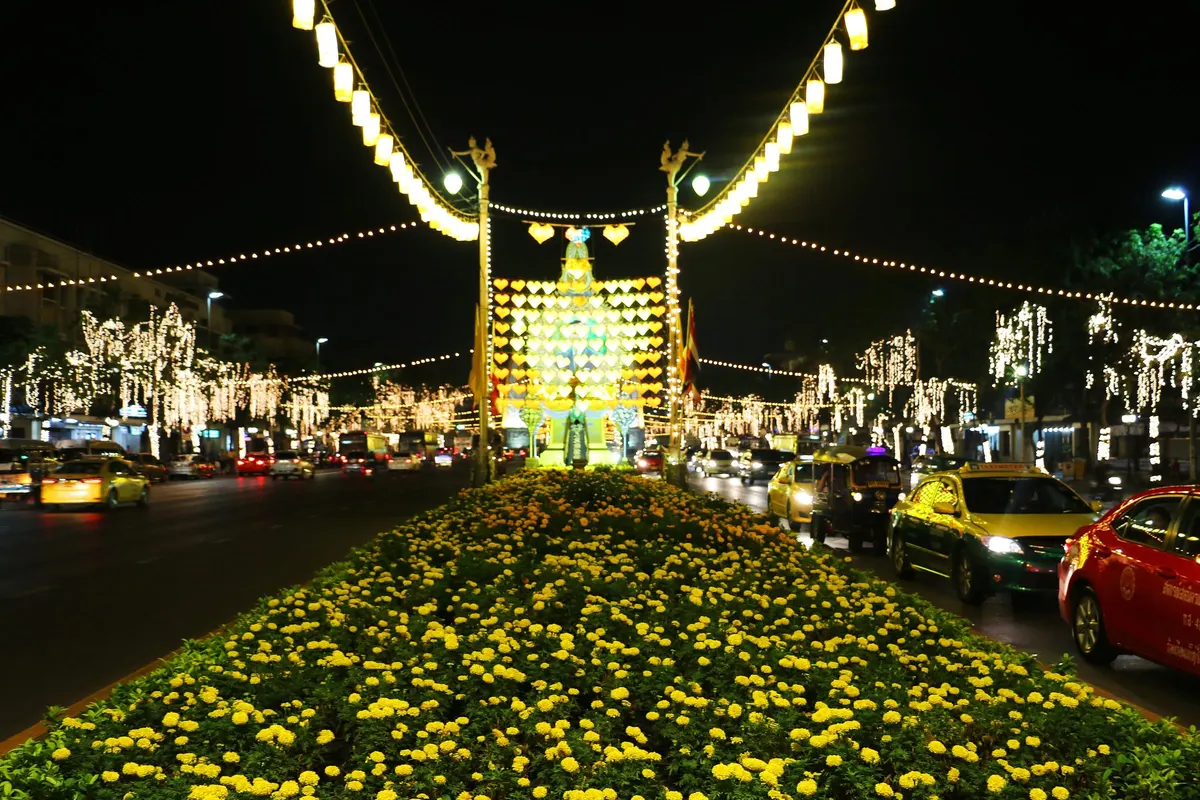 Ratchadamnoen Klang Road lit with festive lights above marigold beds